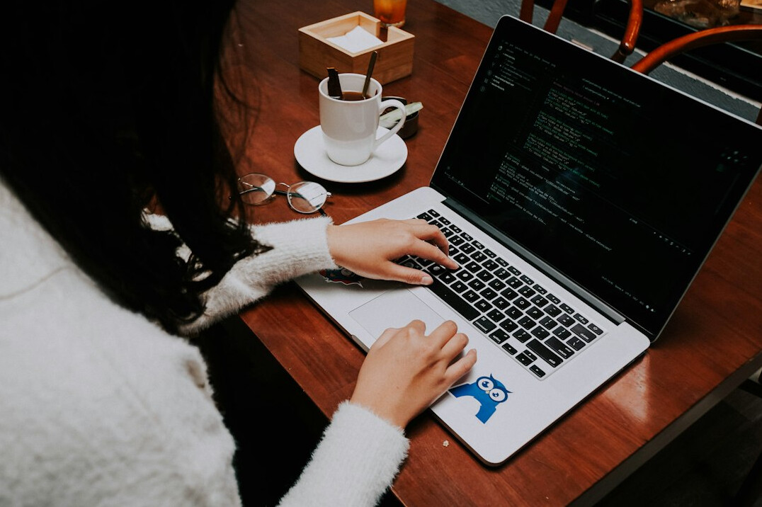 programmer typing code on laptop